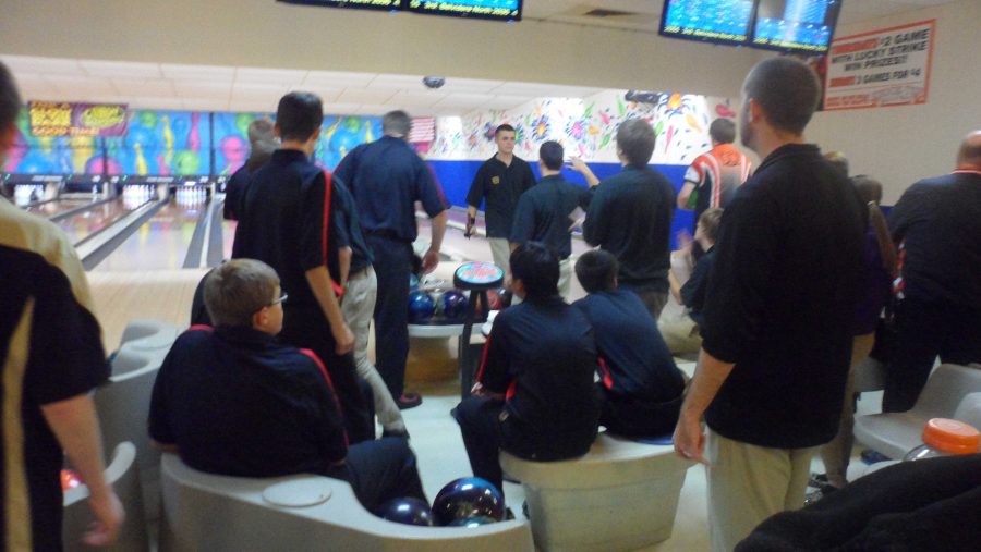 Bowlers watch teammates bowl during the match