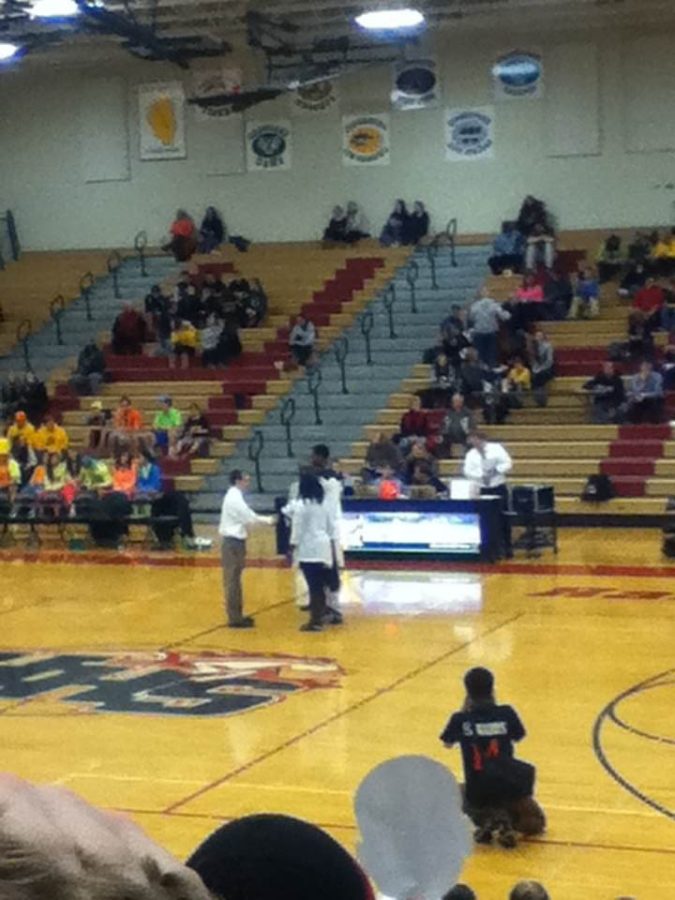 Senior Amanze Egekeze shakes hands with Coach Marty Manning on Senior Night