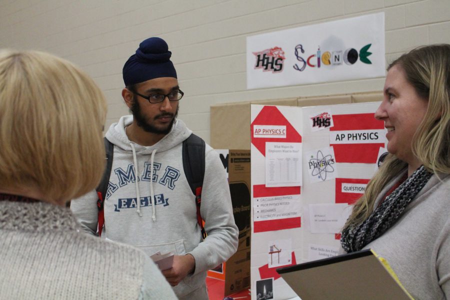 Junior Paul Singh visits the Science booth to talk with Cindy Fuhrer and Melanie Lyons on science electives