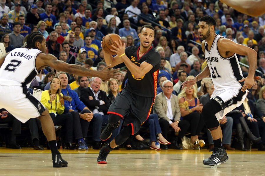 The Golden State Warriors Stephen Curry (30) drives past the San Antonio Spurs Kawhi Leonard (2) and Tim Duncan (21) in the first half at Oracle Arena in Oakland, Calif., on Friday, Feb. 20, 2015. (Ray Chavez/Bay Area News Group/TNS)