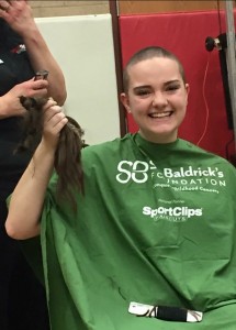 Hennessy holding up her hair after "braving the shave." Bald never looked so good! (Courtesy of Facebook).
