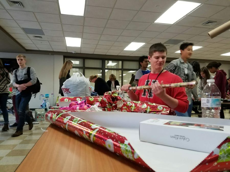 Students wrap presents for the Adopt-a-Family wrapping day in the commons. (S. Faheem)
