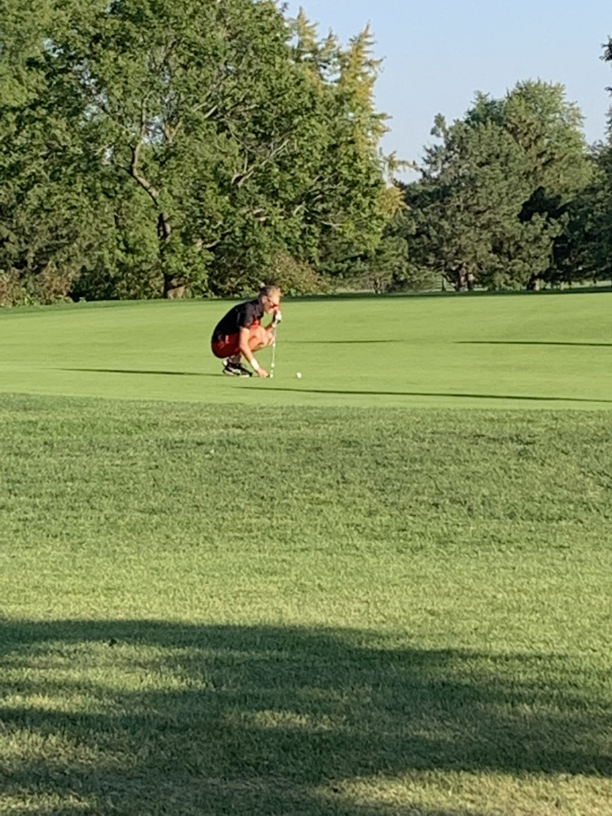 Senior Abby Goraj marks her ball after it lands on the green. (H. Brown)