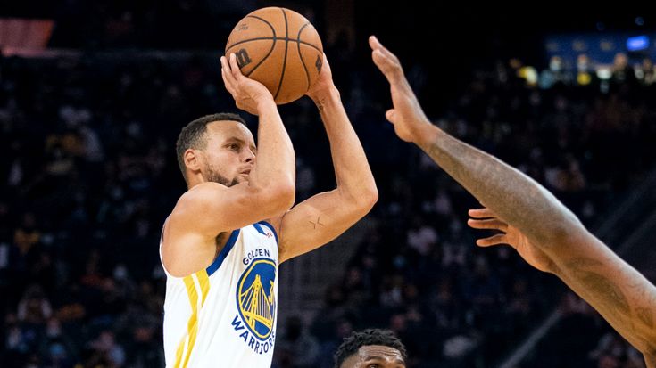 Basktball player Steph Curry shoots and scores.