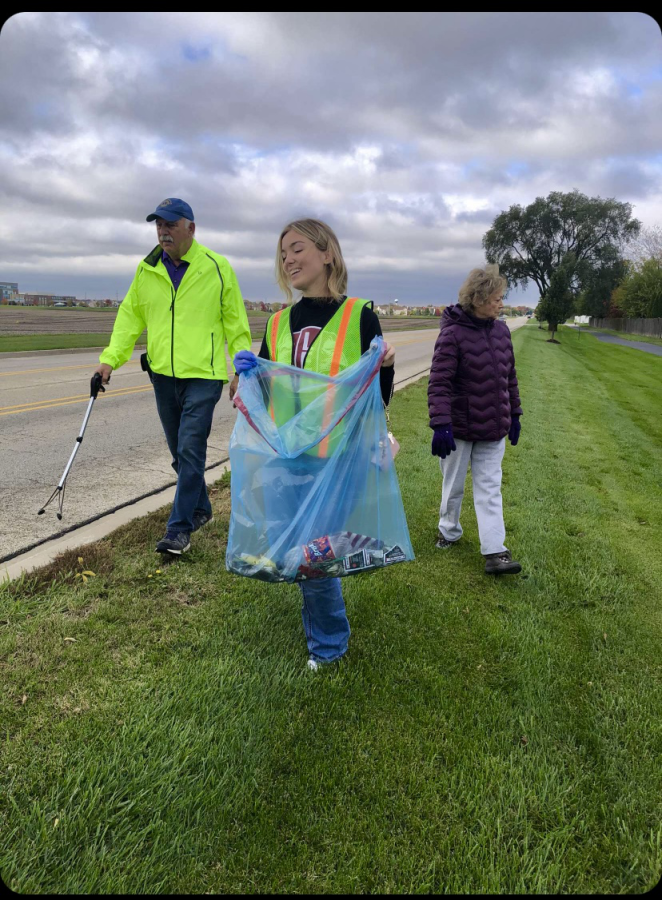 Maria picks up trash with fellow volunteers. 