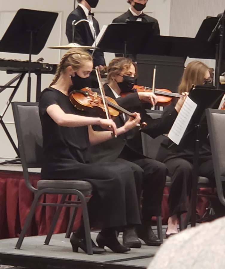 Melanie Gyorke playing the violin at a general orchestra concert.