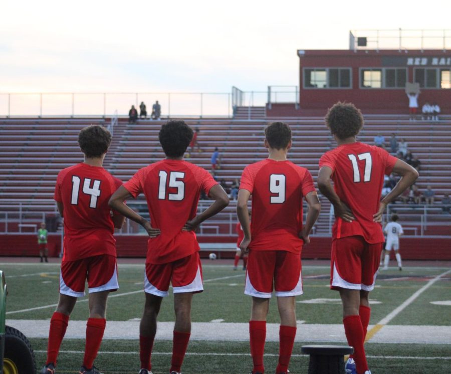Seniors John Lengle, Ansel Dias, Ethan Pfeifer, and junior Talon Sargeant stand together in front of the field, embracing their success as a team.