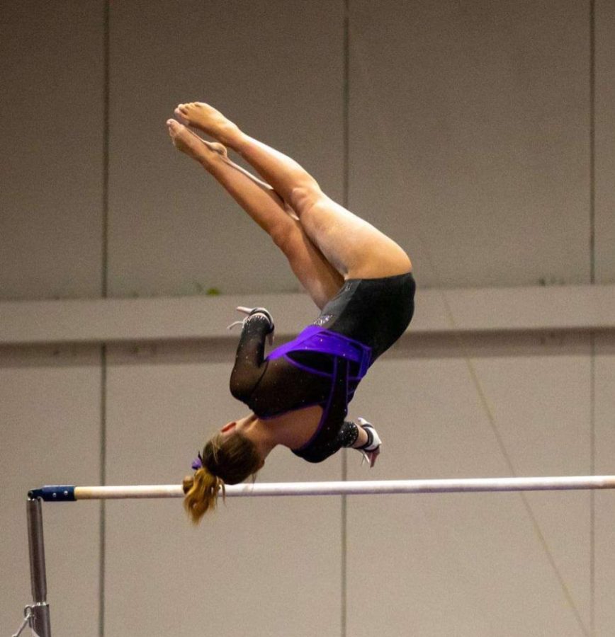 Taylor+demonstrates+her+skills+and+dedication+to+gymnastics+while+on+the+bar.