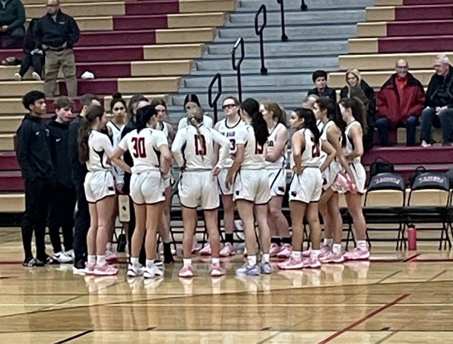 The Huntley varsity basketball team in a huddle talk about how to best work together on the court.