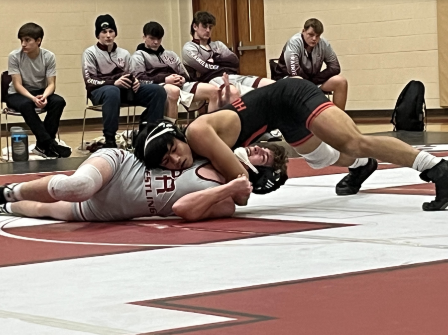 Huntley wrestler holds his position against Prairie Ridge wrestler.