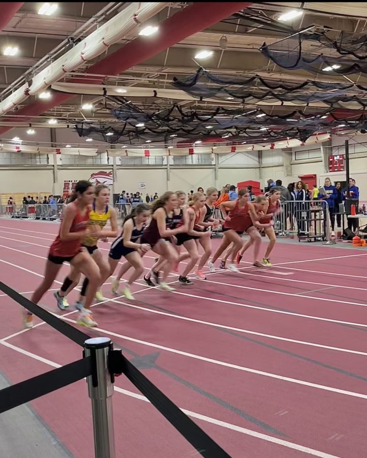 Girls JV track and field runners line up at the start before their race.