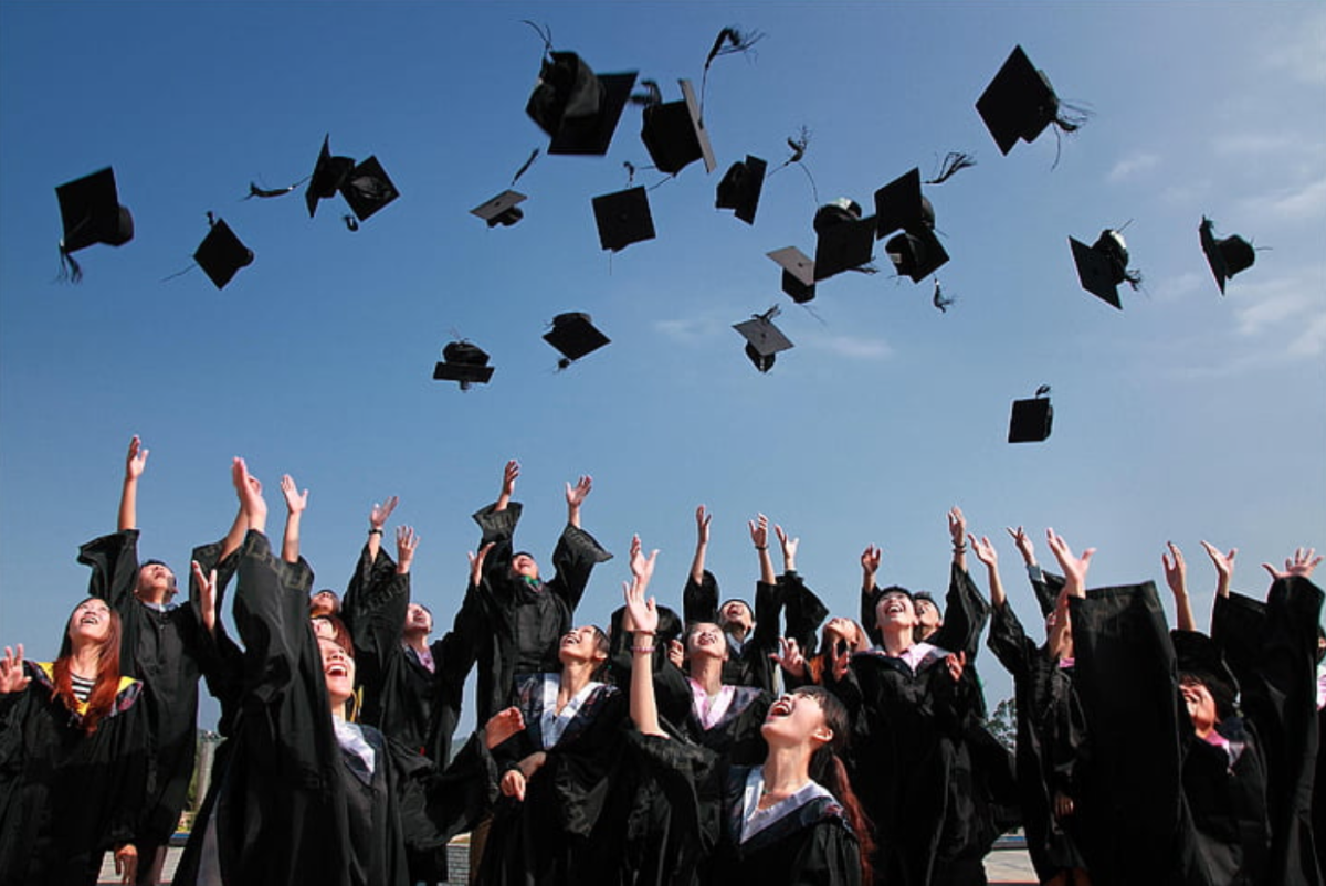Students toss their caps in the air with excitement as they close a chapter of their life.