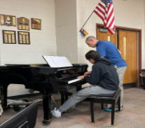 Instructor Rick Rhode shows pianist Will Geske the rhythm that he wants Geske to play alongside the others in the rhythm section.

