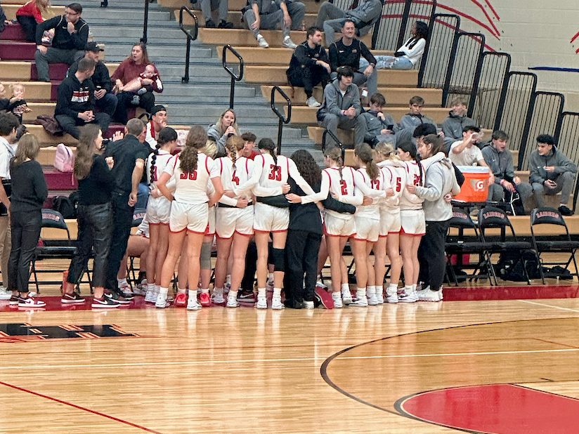 Huntley’s girls varsity basketball team huddles together after a dominating play on the court. 
