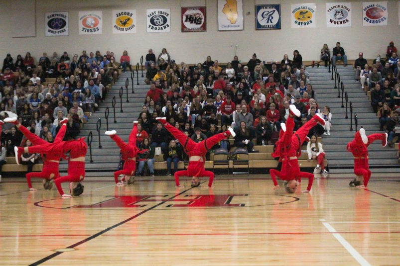 Members of varsity RDT mid-trick, wowing the crowd behind them with their dazzling moments and vibrant outfits.