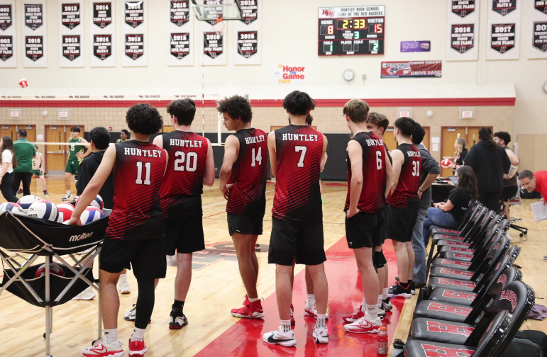 Players from Huntley boys varsity volleyball team observe their team compete against Boylan Catholic High School.
