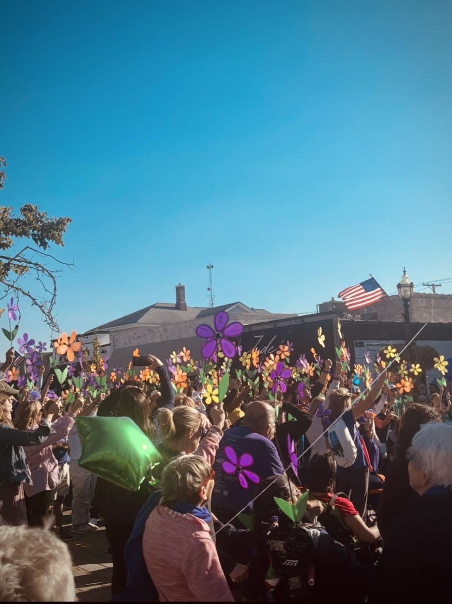 Participants raise their flowers to show support and pay tribute to those with Alzheimer’s. 