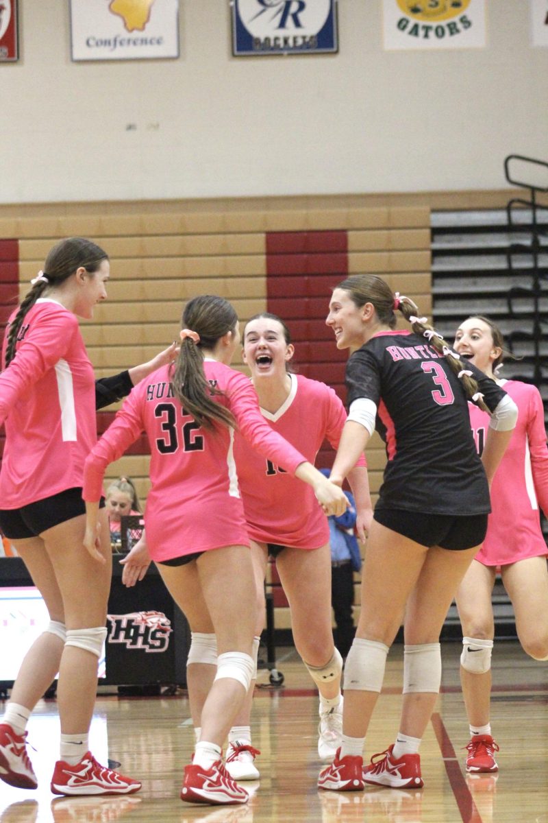 Varsity team cheering as they win the first set.