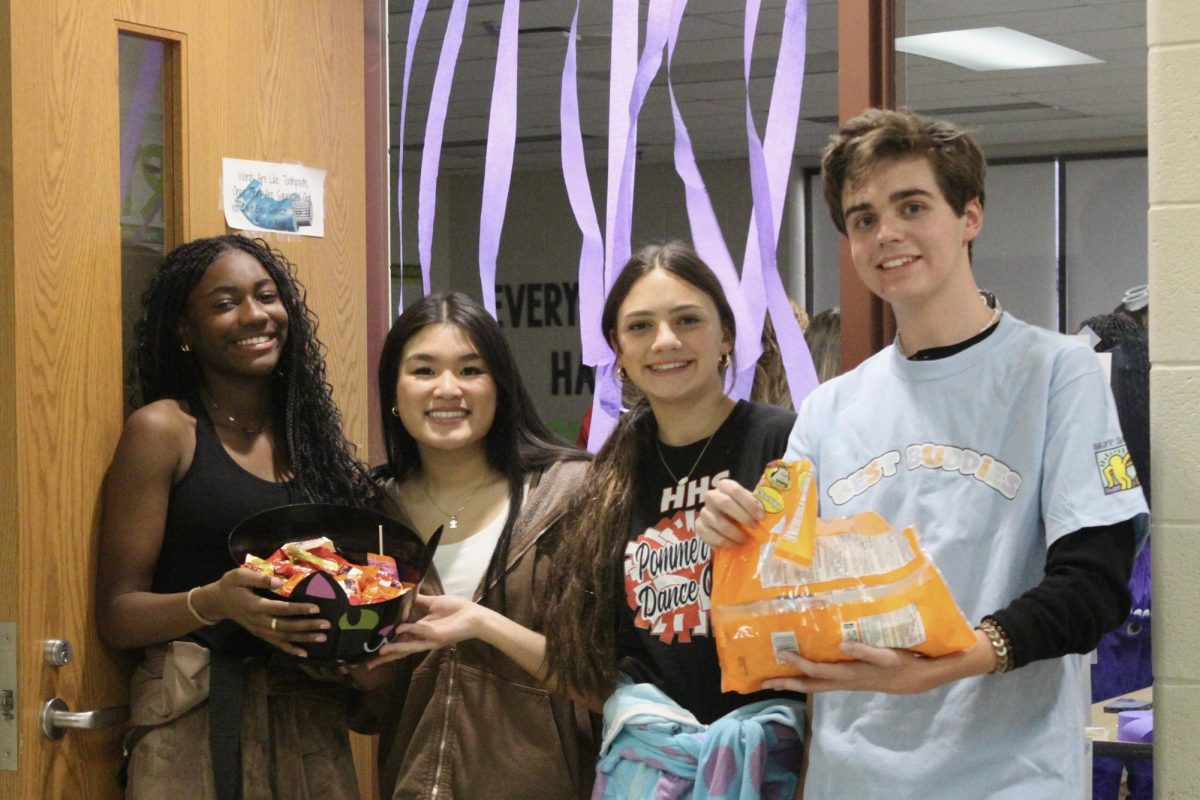 Members of Buddies Club posing with their candy as they get ready for trick-or-treaters.