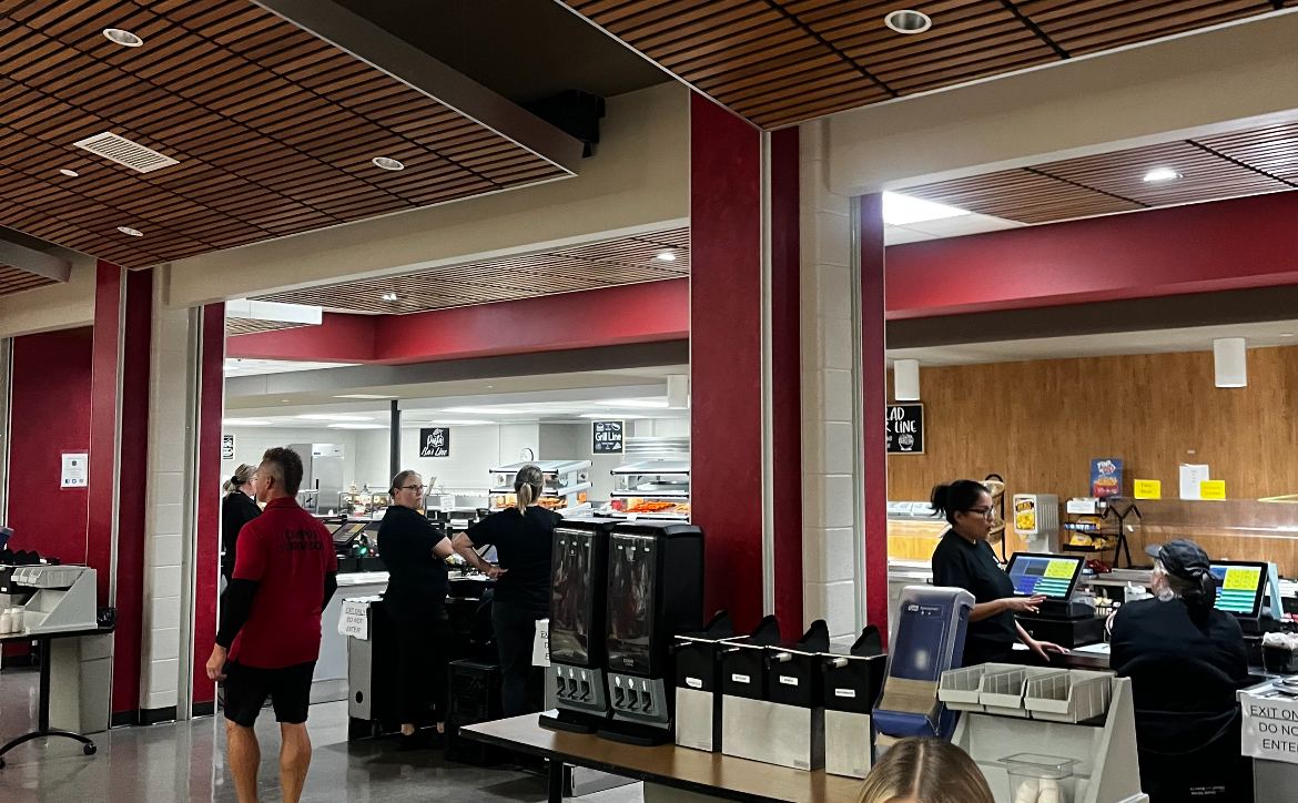 Cafeteria staff and campus supervisors monitor the lunch room as students eat.