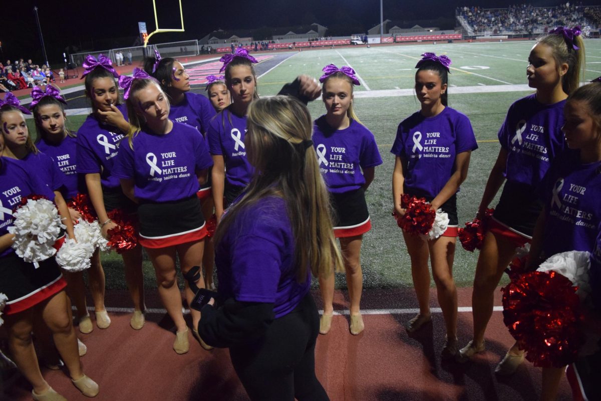 Varsity dance coach Cadence Niccum giving the team a pep talk and reminding them of the routine changes.