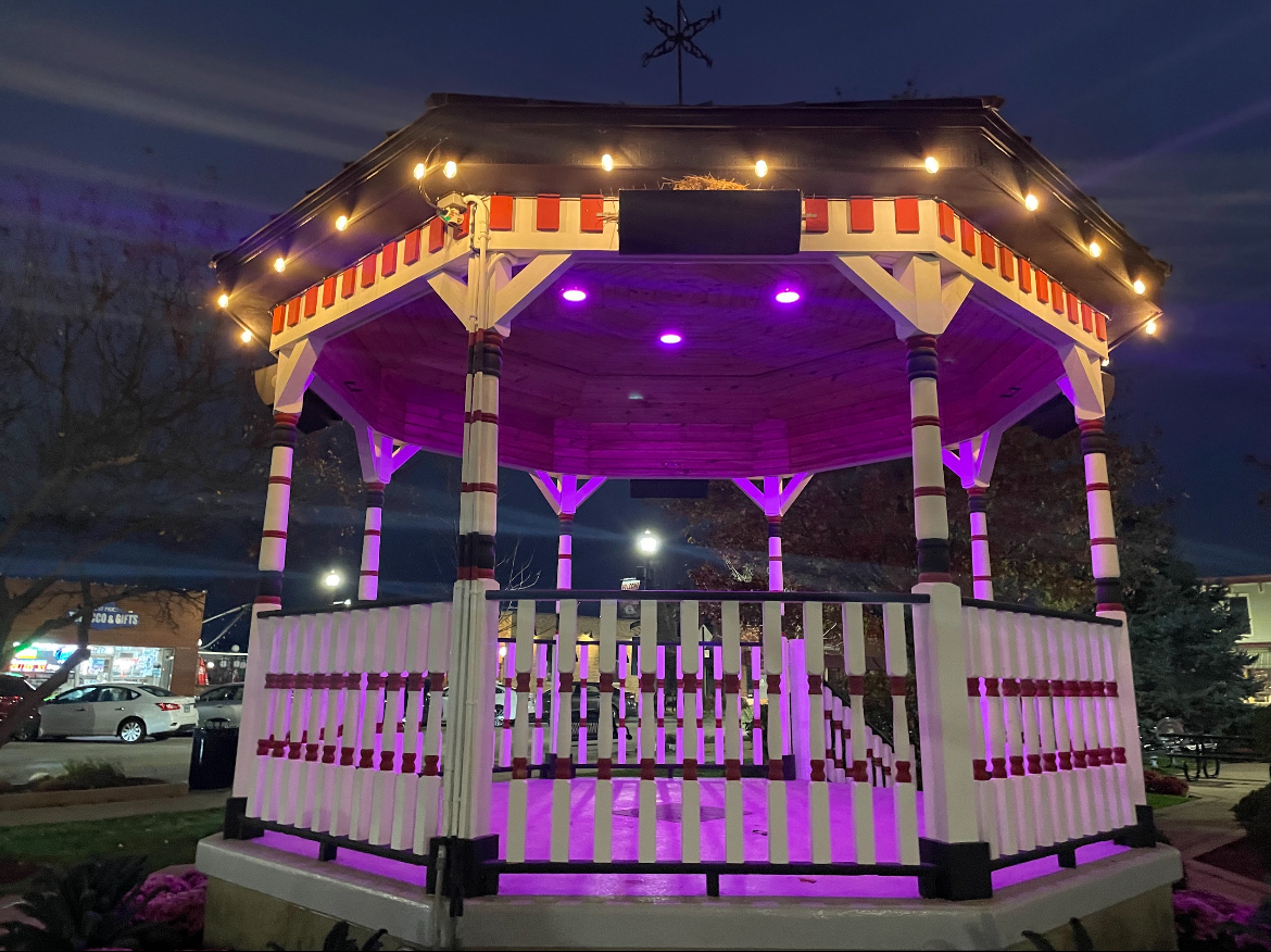 Downtown Huntley gazebo lit up with orange and purple lights.