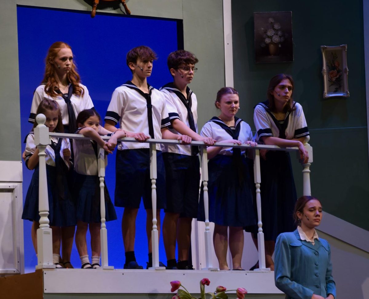 The Von Trapp children watching from the balcony as their father refuses to serve in the Nazi Navy. 