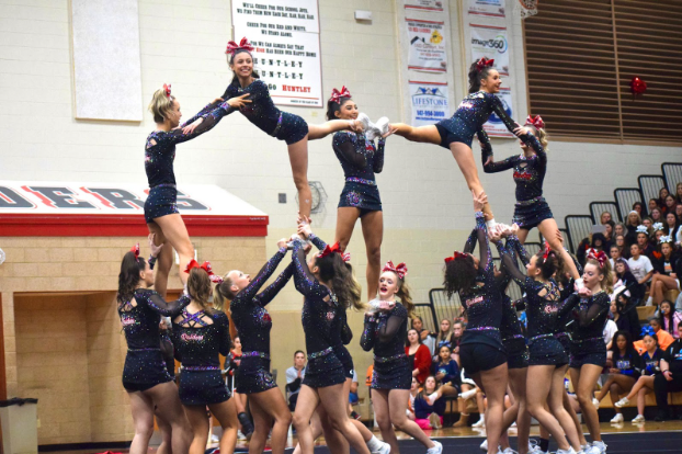 Huntley cheerleaders hitting their pyramid in excitement.